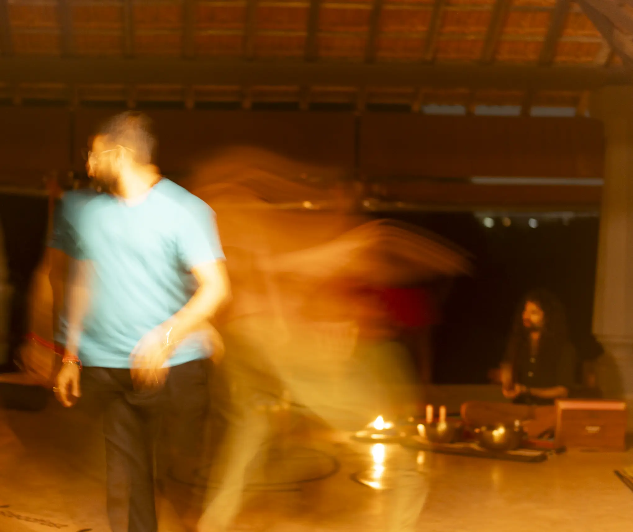 Man in motion blur with warm light trails during a night movement practice.
